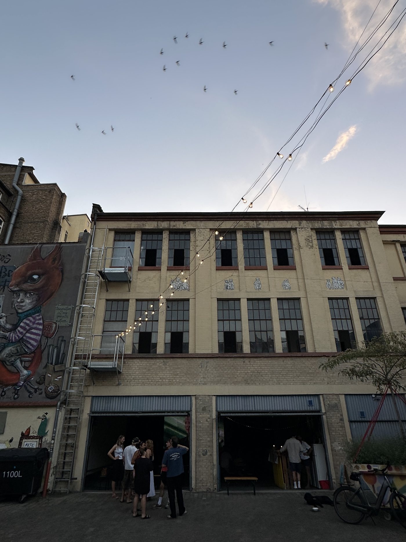 Der Ollohof: Hinterhof mit Lichterkette und Graffiti-Kunst an der Fassade